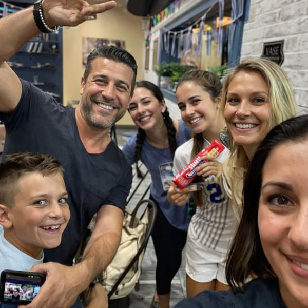 A smiling family poses for a selfie inside Souvlaqueria, a Greek restaurant.